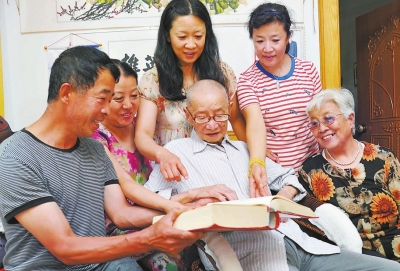 一家人圍在一起，饒有興趣地翻閱永定蘇氏族譜。