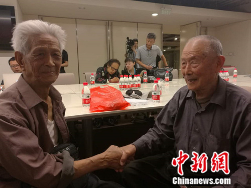 閆玉成老人(右)與另一位受害中國勞工趙宗仁握手。 張尼 攝