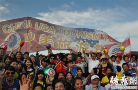 快閃活動參加者在“中美旅游年”橫幅前合影留念。(《僑報》記者徐一凡攝)