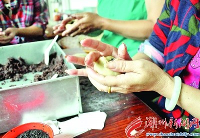 包餡，取小面團(tuán)手工捏開后放進(jìn)豆泥餡料，包捏起來。