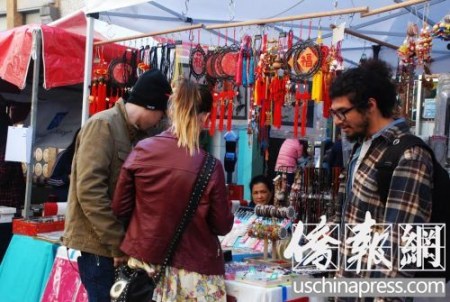 白人游客也來(lái)逛街會(huì)，對(duì)中國(guó)手工藝品愛(ài)不釋手。(美國(guó)《僑報(bào)》/吳卓明 攝)