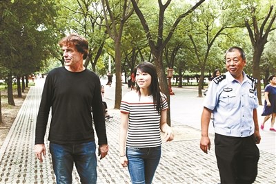 女孩和養(yǎng)父、民警在一起。(圖片來源：北京青年報)