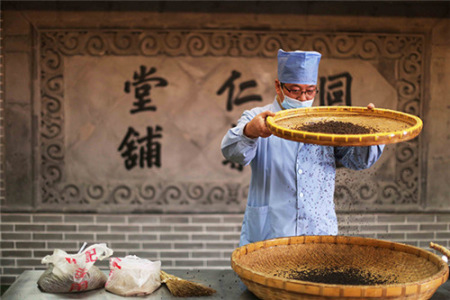 北京同仁堂集團(tuán)股份有限公司一位藥劑師正在制作中藥。(圖片來源：《人民日?qǐng)?bào)》)