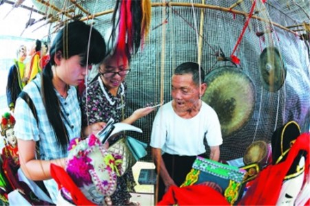  一位70多歲的客家提線木偶老藝人，正在接受龍巖當(dāng)?shù)卮髮W(xué)生的訪問。