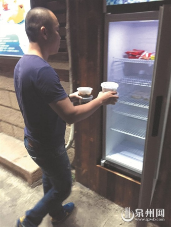 牛肉館工作人員往冰箱里存放食品 牛肉館工作人員往冰箱里存放食品