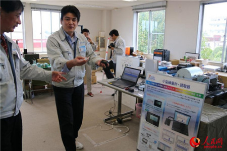 王社長(zhǎng)讓工作人員展示小型輻射監(jiān)測(cè)儀與讀取器。