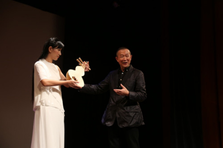 譚盾(右)介紹藉由敦煌古畫而還原出的“反彈琵琶”所用樂器。(美國(guó)《世界日?qǐng)?bào)》/洪群超 攝) 