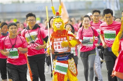 大圣歸來(lái) 孫悟空手持“金箍棒”與馬拉松參賽者們并肩奔跑。