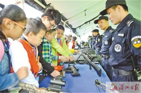 日前，市公安局舉行警營(yíng)開(kāi)放日，邀請(qǐng)各界群眾代表走進(jìn)警營(yíng)，體驗(yàn)警營(yíng)生活、了解公安工作，進(jìn)一步促進(jìn)警民關(guān)系。圖為部分學(xué)生代表正在了解槍械知識(shí)。 記者 吳偉鋒 攝