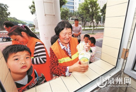 領(lǐng)到饅頭和豆?jié){，環(huán)衛(wèi)工人笑開懷。(戴涵琦 攝)