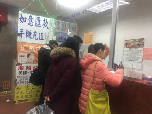 春節(jié)將至，不少華裔民眾紛紛前往各個(gè)匯款點(diǎn)給家人匯款。(美國(guó)《世界日?qǐng)?bào)》/黃伊奕 攝)