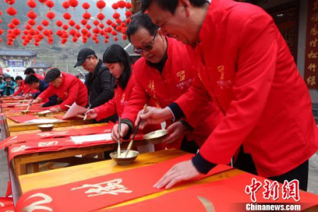 印江縣書(shū)法愛(ài)好者書(shū)寫(xiě)對(duì)聯(lián)。　周燕玲 攝