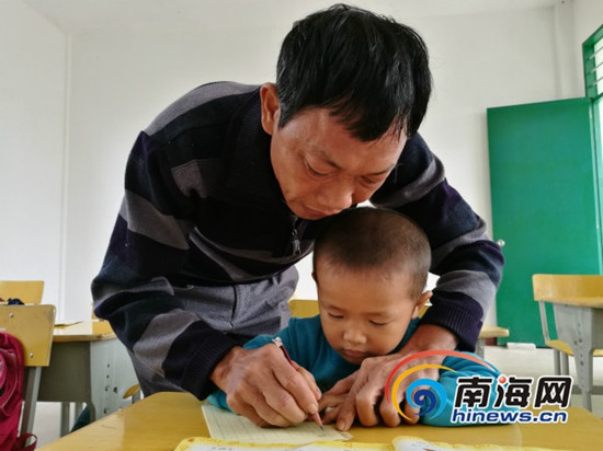 吳光明教孩子們寫字。南海網(wǎng)記者 高鵬 攝