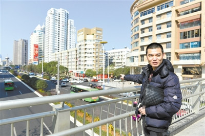 在新城天橋上，童洪建對(duì)家鄉(xiāng)巨變贊賞有加。楊冰杰 攝