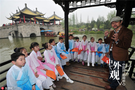 2016年4月2日，江蘇揚(yáng)州瘦西湖景區(qū)，央視詩詞大會(huì)擂主給揚(yáng)州市汶河小學(xué)國(guó)學(xué)班的孩子們講授有關(guān)揚(yáng)州詩詞，孩子們身著古裝，跟隨夏昆老師邊游邊學(xué)，孩子們?cè)诔浞钟斡[的同時(shí)學(xué)習(xí)國(guó)學(xué)文化。(劉江瑞)