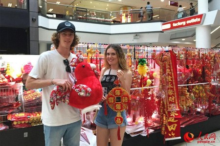 悉尼唐人街購物中心里，一家售賣中國傳統(tǒng)特色商品的店鋪顧客絡(luò)繹不絕，商鋪里里外外都掛滿了中國結(jié)、紅燈籠、春聯(lián)、年畫……正忙碌地招呼著顧客的朱太太是小店的老板，她喜氣洋洋對本報記者說：“我在唐人街開店12年了，春節(jié)前后是每年生意最好的時候。現(xiàn)在，許多澳大利亞當(dāng)?shù)厝撕陀慰投枷矚g采購一些中國結(jié)、燈籠等裝飾品，給家里”澳大利亞姑娘格蕾絲對圖為顧客正在挑選春節(jié)裝飾品。（人民網(wǎng)記者鮑捷 攝）