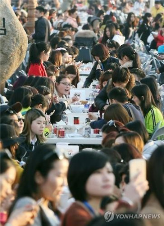 資料圖片：2016年3月28日下午，在仁川市月尾島文化街，幾千名傲瀾員工一起吃炸雞喝啤酒。(韓聯(lián)社）