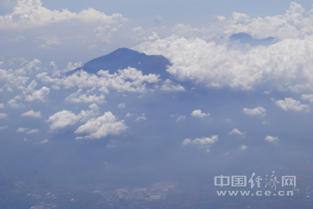 自2015年印尼對(duì)中國游客實(shí)施免簽征政策以來，除巴厘島、日惹等傳統(tǒng)旅游熱點(diǎn)，印尼政府積極向中國游客和投資者推介新的旅游目的地。圖為印尼中爪哇省旅游名城瑪瑯市郊的活火山——阿朱納火山，山腳下就是星羅棋布的村落，中方公司目前正協(xié)助當(dāng)?shù)亻_發(fā)火山相關(guān)旅游項(xiàng)目。中國經(jīng)濟(jì)網(wǎng)記者田原 攝