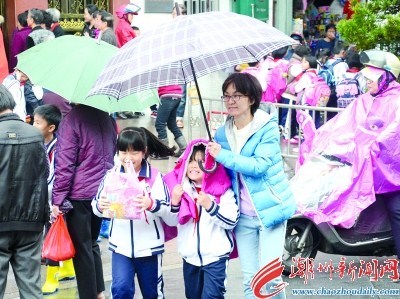 2月22日上午十點多，在市區(qū)一所小學(xué)門口，家長們撐著傘接送學(xué)生放學(xué)回家。