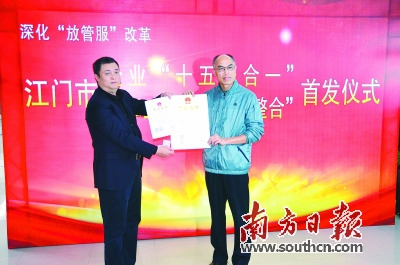 江門市市長鄧偉根(右)向江門航天數(shù)聯(lián)科技有限公司總經(jīng)理石磊頒發(fā)全國首張“十五證合一”的企業(yè)法人營業(yè)執(zhí)照。全澤超 攝