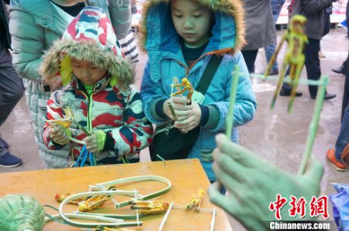 圖為兩個小朋友被“會翻筋斗的猴子”吸引住了。　趙琳露 攝