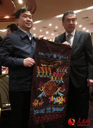 僑辦主任秦春成向廣西鄉(xiāng)親贈送家鄉(xiāng)美麗的壯錦。(謝榮鎮(zhèn)攝)