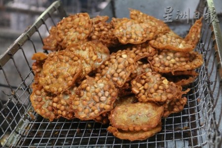 花生餅從油鍋中撈上來，呈金麥色的色澤。（馬來西亞《星洲日?qǐng)?bào)》）