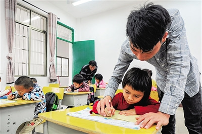 吳志平教學(xué)生寫字，父親吳光明也沒有閑著。