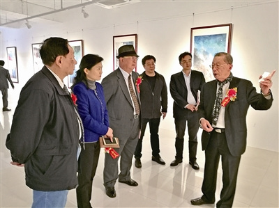 古銑賢（右一）向參觀者介紹畫展。