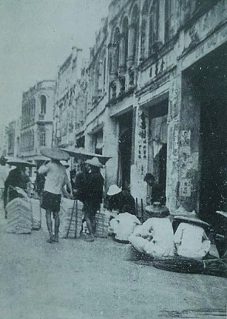 1939年，瓊海嘉積街上戴斗笠的人們。