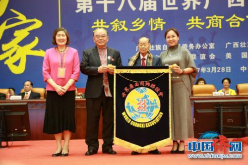圖為韋誠向第十九屆世桂聯(lián)大會主辦單位日本廣西同鄉(xiāng)會移交會旗.　王希 攝