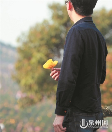 泉州宏福園，一位市民拿著黃色紙菊花準(zhǔn)備祭拜逝者。（潘登/攝）