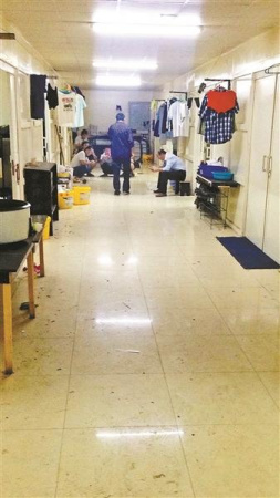 滯留工人聚集在宿舍樓道里，自2月起他們已被困了45天