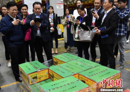 圖為華文媒體參觀重慶西部物流園參觀一貨品分揀倉庫，為重慶小面點(diǎn)贊?！≈芤?攝