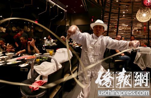 海底撈火鍋店的菜香，服務也具特色，“舞面師”在客人桌前表演。(僑報記者邱晨攝)