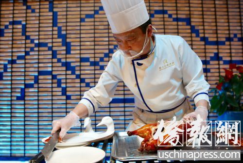 眉州東坡的烤鴨有特色，一位師傅在片烤鴨肉。(僑報記者邱晨攝)