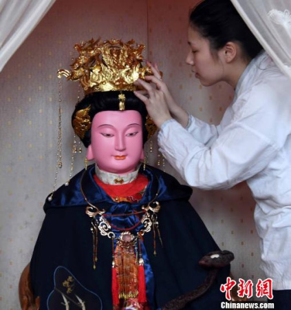 一名福州三坊七巷郎官巷天后宮道士更衣沐手、上香拜謁后為媽祖軟身神像戴上鳳冠?！∮浾邉⒖筛?攝