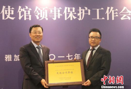 圖為謝鋒為2016年度領(lǐng)保聯(lián)絡(luò)員工作先進(jìn)合作單位——印尼中國(guó)商會(huì)總會(huì)頒發(fā)獎(jiǎng)牌。林永傳　攝