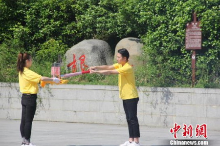 圣火采集手將火種對(duì)準(zhǔn)圣火采集器，點(diǎn)亮火種燈。沈春艷 攝