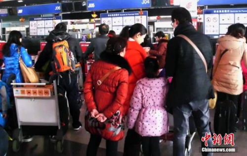 北京首都國(guó)際機(jī)場(chǎng)的乘客在排隊(duì)辦理登機(jī)手續(xù)。(資料圖)<a target='_blank' >中新社</a>發(fā) 錢興強(qiáng) 攝
