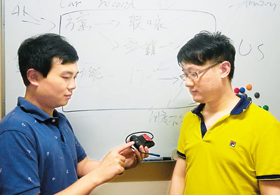 吳偲越（左一）與合伙人在討論行車記錄儀的上市方案。