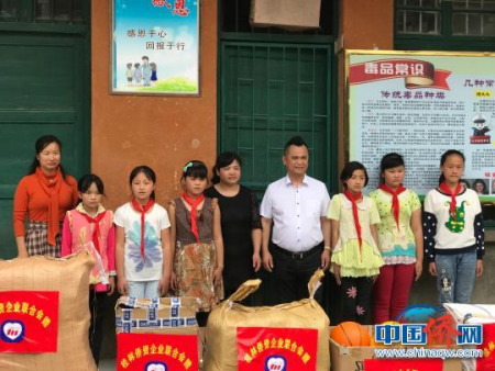 桂林僑資企業(yè)聯(lián)合會陳隆魁會長(右四)向灌陽縣水車鄉(xiāng)完小師生捐贈圖書、體育器材、教學用品等慰問物品?！￡懹⒈?攝
