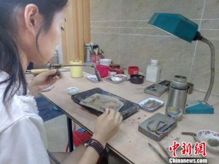 23歲的楊麗正在焊接銀花絲制品?！⊥貔i 攝
