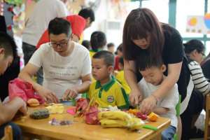 ④ 昨日，油竹街道慧果幼兒園舉行“六一”暢享美食活動，讓小朋友們度過一個難忘、愉快、有意義的節(jié)日。圖為小朋友們在制作水果拼盤。張永益