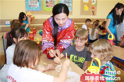中國(guó)老師教小朋友使用筷子。