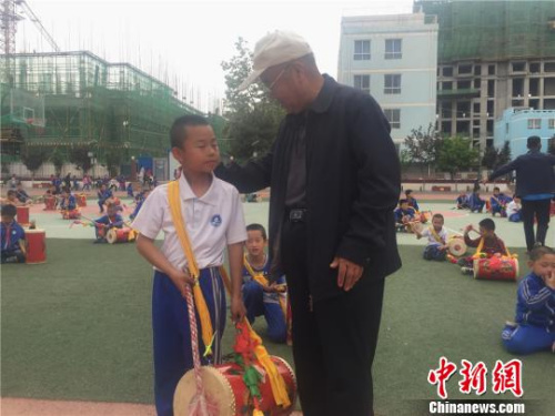 65歲的魏永宏被當?shù)胤Q為“蘭州鼓王”，他也是學生們口中的“爺爺級”教練。魏永宏將太平鼓“搬進”學校，免費為孩子們傳授這項“絕技”?！∈缝o靜 攝