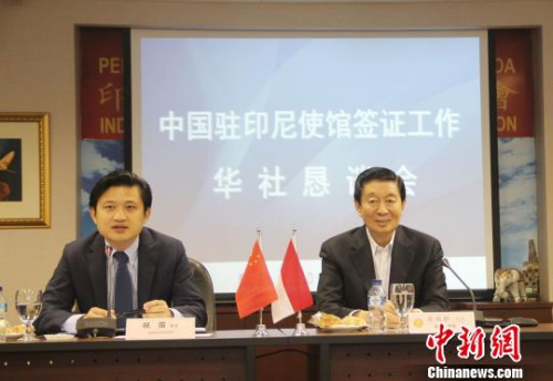 圖為中國駐印尼大使館領(lǐng)事參贊祝笛(左)介紹簽證政策?！×钟纻?攝