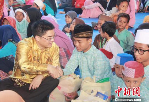 圖為顧景奇向孤兒和貧困兒童發(fā)放禮包?！∏貫榉?攝