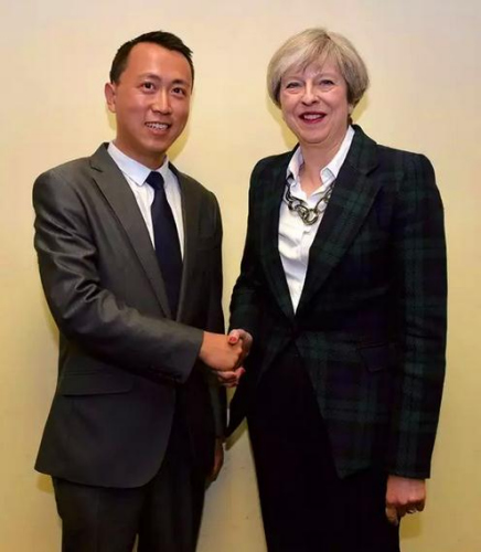 參加2017年英國大選的華裔候選人何易與英國首相特雷莎·梅合影。(受訪者供圖)