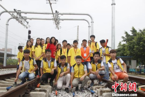 華裔青少年在軌道上合影?！≈炝?攝